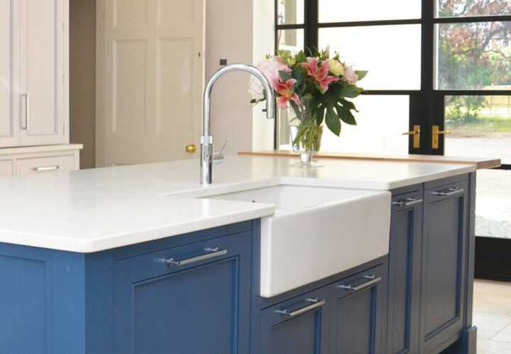 handmade blue cabinets on a kitchen island with a belfast sink